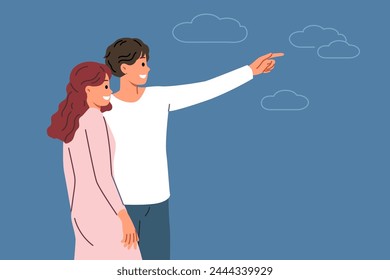 Couple in love with man pointing finger in direction telling bride about plans for future. Romantic couple of boyfriend and girlfriend look into distance dreaming of good honeymoon