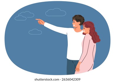 Couple in love with man pointing finger in direction telling bride about plans for future. Romantic couple of boyfriend and girlfriend look into distance dreaming of good honeymoon