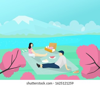 A couple lover picnic in the cherry blossom flower viewing festival in spring times.