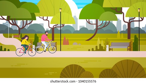 Couple Riding Bicycles In Public Park Over City Building Skyline Background Man And Woman Cycling Outdoors Flat Vector Illustration