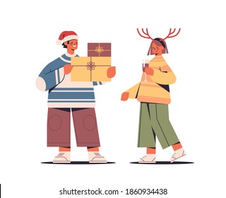 couple in santa claus hats having fun with presents gift boxes happy new year and merry christmas holidays celebration concept horizontal full length vector illustration
