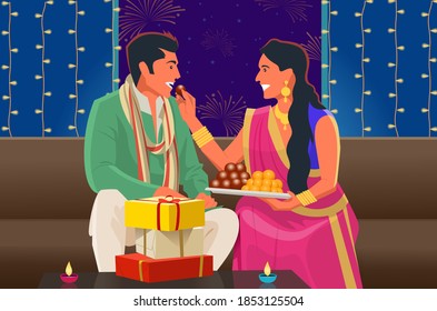 A couple shares sweets during Diwali festival.