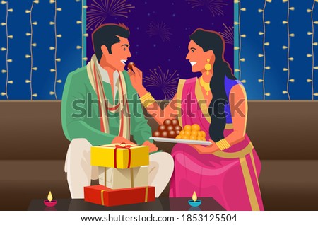 A couple shares sweets during Diwali festival.