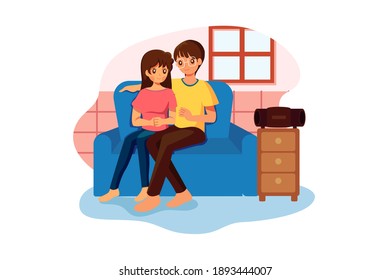 Couple Sitting On Sofa Listening To Music On Wireless Speaker