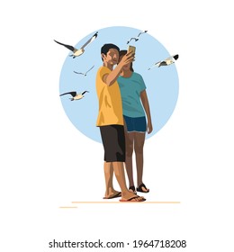 A couple standing by the sea to take a selfie.