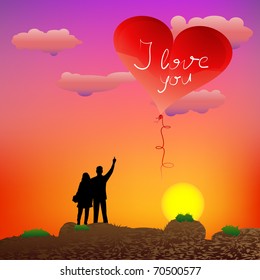 Couple standing on the rocks and guy showing heart-shape balloon at sunset