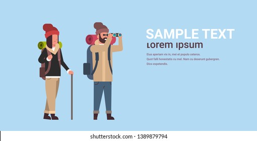 couple of tourists hikers with backpacks man looking through binoculars woman holding stick hiking concept travelers on hike horizontal full length copy space flat