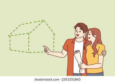 Couple visualizes buying new house with mortgage or renting large apartment in good neighborhood. Young happy man and woman smiling planning to build eco house for family life together