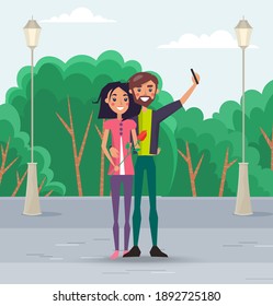Couple walking outdoors in the city park. Cute happy smiling girl and guy are taking selfie. People smiling and hugging posing for a photo on the phone. Family romantic weekend in the open area