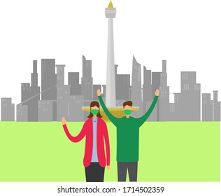 Couple wearing face mask in front of the National Monument in Jakarta