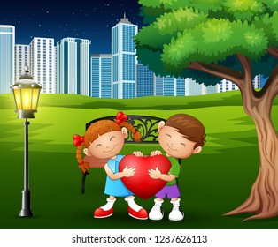 A couples holding red heart shape in the city park