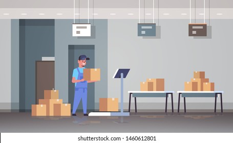courier man in uniform putting parcel box on scales mail express delivery logistic service concept modern warehouse interior flat horizontal full length