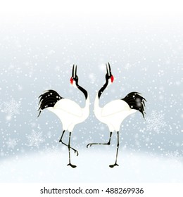 courtship dancing brace of red-crested white cranes in snow