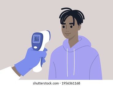 Covid-19 prevention, a hand holding a Medical Infrared Thermometer, a young male Black patient being checked for a body temperature