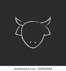 Cow head hand drawn in chalk on a blackboard vector white icon isolated on a black background.