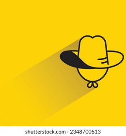 sombrero de vaquero con sombra sobre fondo amarillo