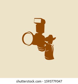 A cowboy holding a camera instead of a gun