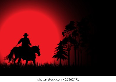 Cowboy on a horse over sunset