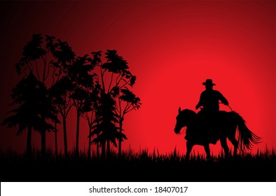 Cowboy on a horse over sunset