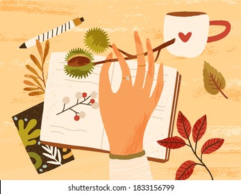 Cozy autumn composition with hand holding branch with chestnut, fall leaves, berries, notebook, pen and a cup of hot beverage. Autumnal hygge atmosphere. Flat textured vector illustration