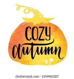Cozy autumn. Fall quote vector illustration isolated on background of a pumpkin watercolor stain. Vector ink lettering. Modern calligraphy style.