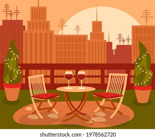 Cozy beautiful garden on rooftop with table and two chair in the big city with the cityscape on sunset