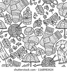 Cozy fall hand drawn vector seamless pattern. Autumn doodle detailed illustration with coziness ornate elements - mushrooms, clothes, acorn, thread, knitting, candle, chestnut and more.