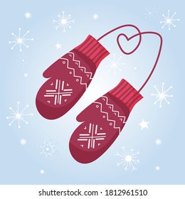 Cozy knitted red mittens with ornaments and snowflakes. Warm clothes to protect hands from cold in winter. Against the background of white snowflakes. New Year's holiday and Christmas mood. 