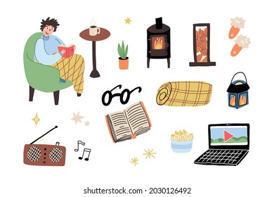 Cozy winter, Christmas holidays pastime set. A guy sitting in the chair, reading the book. Audio speaker, potbelly stove, tartan throw blanket, slippers, laptop with movie on the screen and a popcorn.