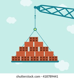 Crane with bricks. Crane carrying bricks. Blue sky in the background.