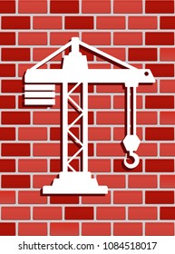 icono de grúa en la pared de ladrillo