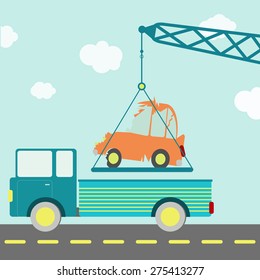 Crashed car on a truck. Crane carrying a crashed car being put on a truck on the road. Blue sky in the background.