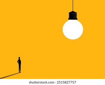 Creation. Businessman looks at a big light bulb
