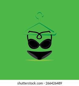creative black women underwear garment over green background with hanging on hanger 