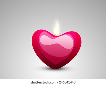 Creative glossy candle in heart shape on grey background for Happy Valentines Day celebration.
