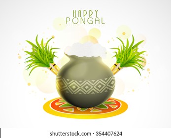 Creative glossy mud pot, full of rice with sugarcanes on rangoli for South Indian harvesting festival, Happy Pongal celebration.