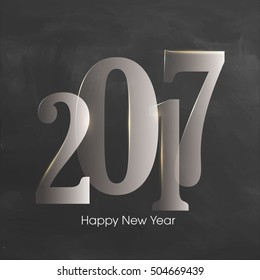 Creative glossy text 2017 on chalkboard background for Happy New Year celebration.