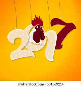 Creative hanging text 2017 with rooster on yellow background for Chinese New Year or Year of the Rooster celebration.