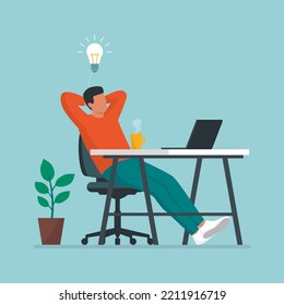 Creative man sitting at desk and taking a break, he is relaxing with hands behind head and having a good idea