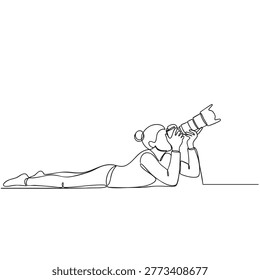 Creative woman photographer lying down taking photos with lens.