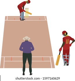 Cricket field with players on bases and referee