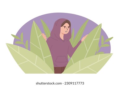 Criminal boy in leaves. Young guy in sweater hides in bushes and watches. Teenage criminal prepares crime.
