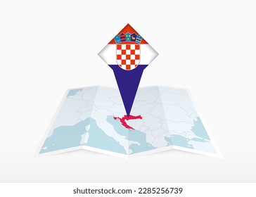 Croatia is depicted on a folded paper map and pinned location marker with flag of Croatia. Folded vector map.