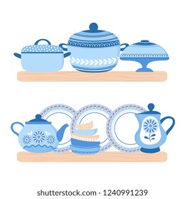 Crockery ceramic cookware. Blue porcelain bowls, plates, teapot and pand on the wood shelfs