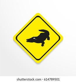 Crocodile. Black and white image in yellow sign on a light background. Vector icon.