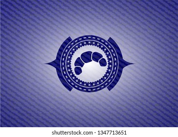 croissant icon inside badge with denim background