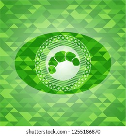 croissant icon inside green emblem with triangle mosaic background
