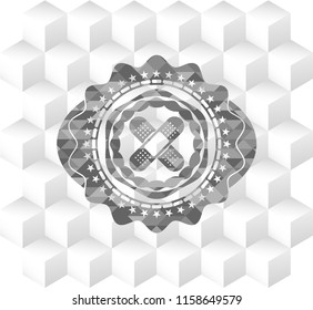 crossed bandage plaster icon inside grey badge with geometric cube white background