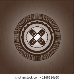 crossed bandage plaster icon inside wood emblem