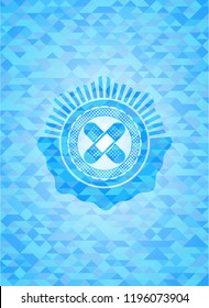 crossed bandage plaster icon inside light blue emblem with triangle mosaic background